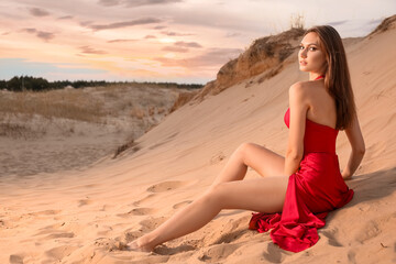 Fototapeta na wymiar Beautiful fashionable young woman in desert