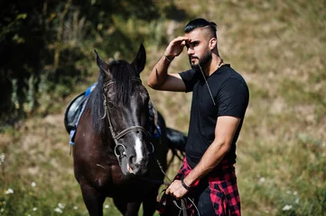 Foto op Canvas Arab tall beard man wear in black with arabian horse. © AS Photo Family