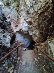 vertical photo of cave entrance with handrail in Thaailand