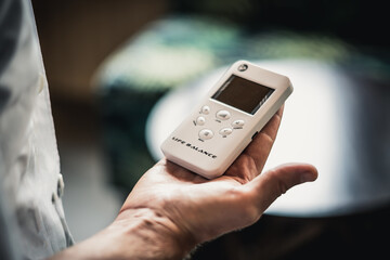 Young man hands hold bio rezonans therapy alternative medicine device, small portable life balance bioresonance for treatment Diseases of the intestinal system