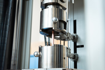 Industrielle Belastungsprüfung eines Metallstücks unter Druck.