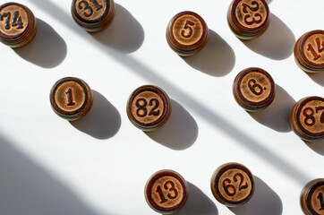 wooden Lotto barrels with sun shadows on a white background