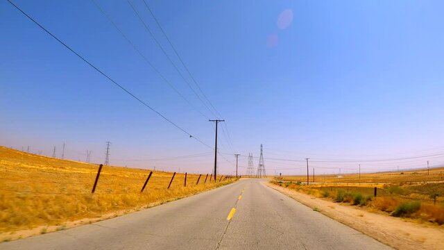 Driving along an empty road in an endless lonesome prairie - driver point of view