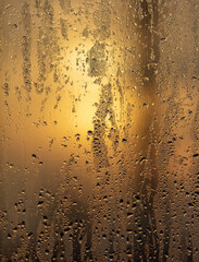 Drops of water on a glass window at dawn as an abstract background.