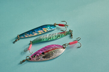 Fishing equipment. Three metal fishing lures on a blue background