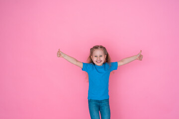 little girl in a blue t-shirt shows a gesture of approval to the class