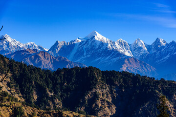 View of Snow cladded Panchchuli peaks falls in great Himalayan mountain range  & alpine grass meadows enroute to Khalia Top trekk trail at small hamlet Munsiyari, Kumaon region, Uttarakhand, India.