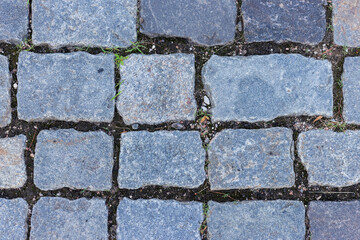Gray, smooth granite paving stones. Paving stone background. An old road.