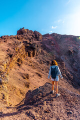 A young woman looking at the crater of the Teneguia volcano on the route of the volcanoes, La Palma island, Canary Islands. Spain