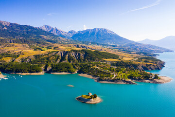 Serene summer landscape of Lake Serre-Poncon, artificial lake surrounded by French Alps, Provence-Alpes-Cote d Azur region - obrazy, fototapety, plakaty