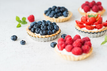 Mini tarts with cream and berries for dessert, selective focus