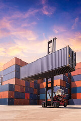 Forklift truck lifting cargo container in shipping yard or dock yard against sunrise sky with cargo container stack in background for transportation import,export and logistic industrial concept - obrazy, fototapety, plakaty
