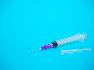 Fototapeta premium Syringe and needle on blue background, injection in hospital