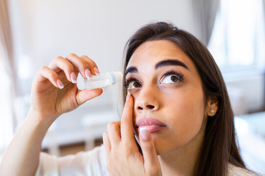 Vision And Ophthalmology Medicine. Closeup Of Beautiful Woman Applying Eyedrops In Her Eyes. Young Female Model With Natural Makeup Using A Bottle Of Eye Drops. Health Concept. High Resolution