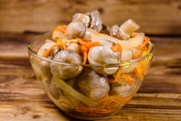 Canned mushrooms with carrot and onion in a ceramic bowl