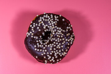 Obraz na płótnie Canvas Donut with chocolate glaze on top isolated on a pink background