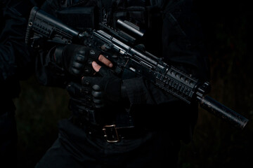 Close up of black assault rifle with collimator sight.