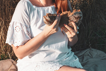 female model plus size having picnic with milk and bread on a field with haystacks, a beautiful young woman with brown hair in white dress, harvest concept