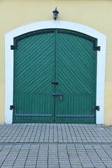 Vintage wooden green doors gates closed with metall padlock with hasp