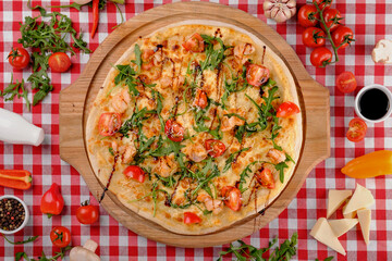 Pizza with seafood, mozzarella, mussels, octopus, squid, salmon, shrimp, cheeseand, fresh rucola and tomatoes sauce, served on a wooden board for a dinner in italian restaurant background, top view
