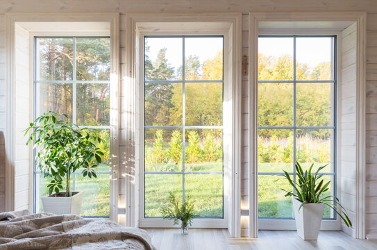 Bright photo studio interior with big window, high ceiling, white wooden floor