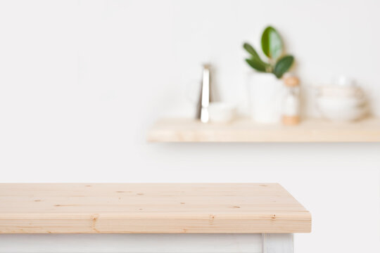 Natural wooden table top and blurred wall with kitchen shelf