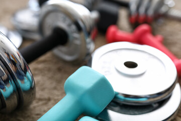 Pile of shiny chrome dumbbells disks lying around grip