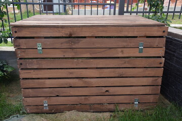Wooden garden composter after grass cutting or lawn mowing for mulching and reusing like fertilizer