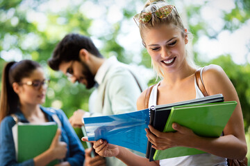 Fototapeta premium Group of happy students studying, preparing together for exam ourdoor