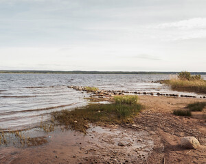 Huge stones on the river bank. Vuoksa river near Imatra in the Leningrad region, Russia. Coastline with birch, pine tree forest reflected in Vuoksa water, near Finland.