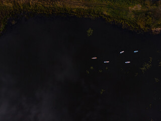Top view of tourists on lake with SUP-boards. Beautiful clear water with people floating on boards engaged in sup-surfing. Seascape with people rowing on boards on background horizon