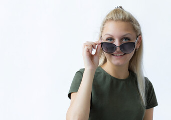 portrait of a girl with blond hair on an isolated white background holds sunglasses in her hand, looks into the distance, dreams of rest