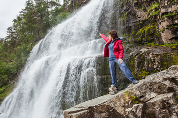 Tourist woman at waterfall Svandalsfossen, Norway