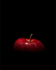 Red apple in the dark, half covered and half in the shade