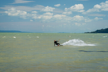 Kiteboarding at lake Balaton in the summer in Balatonfenyves near Fonyód in Hungary. Watersport, kite surfing