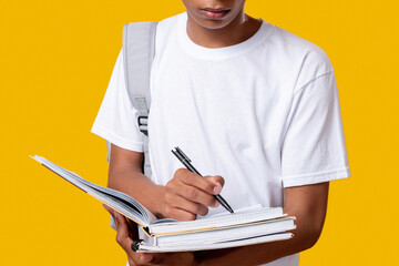 Smart black teenager. Student lifestyle. Unrecognizable african guy writing in notebook isolated on...