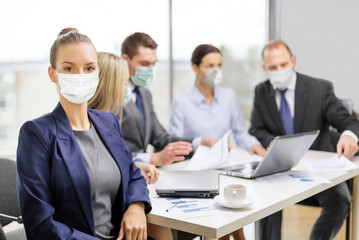 business and pandemic concept - businesswoman wearing face protective medical mask for protection from virus disease at office with team on the back