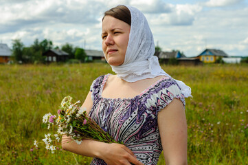 Young woman in vintage clothes with wildflowers