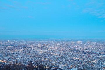 View from top of Mt. Moiwa in Sapporo city, Hokkaido, Japan during winter with night cityscape blur background.