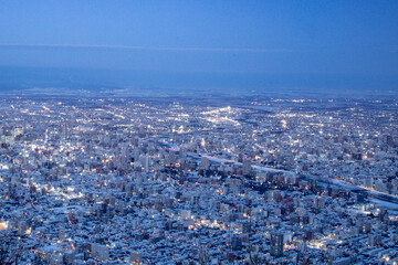 View from top of Mt. Moiwa in Sapporo city, Hokkaido, Japan during winter with night cityscape blur...