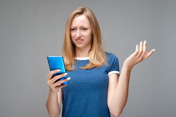 Disturbed Young woman with long chestnut hair using mobile phone. Studio shot, white background, isolated