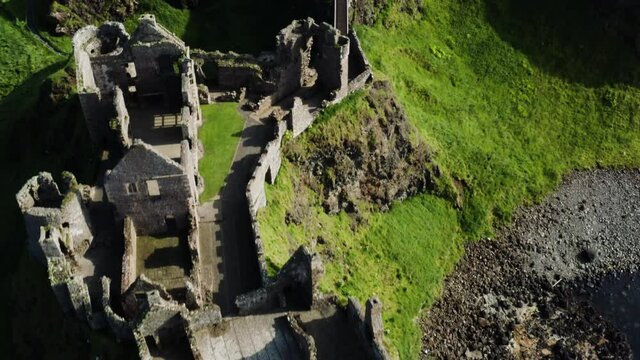 Aerial birdseye shot of the Dunluce Castle during a sunny day.