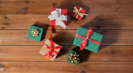 christmas, holidays and celebration concept - gift boxes on wooden boards from top