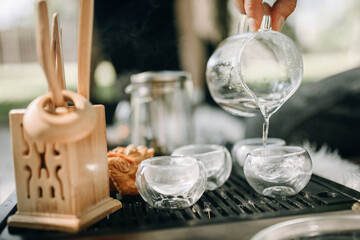 Preparation for the tea ceremony. A man pours boiled water into a glass cup for tea