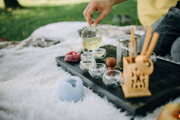 White tea is poured into glass cups. Tea ceremony in the morning in the park