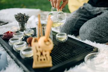 Master of tea ceremony pours green tea into glass cups close up. Tea ceremony in the park