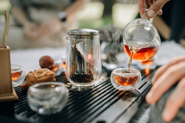 The magic of the morning and the atmosphere of the tea ceremony. Red tea is poured into glass bowls - Powered by Adobe