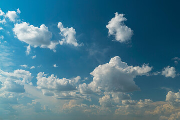 Picturesque white clouds illuminated by sunlight on a blue sky.
