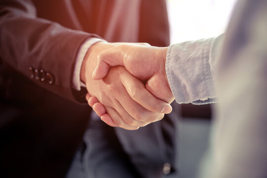Partners shake hands to make a deal, It is a picture of the working atmosphere of company employees in the office in the early 21st century.