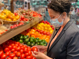 Stylish woman grocery shopping in a face mask